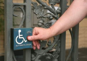man pushing automatic door button with thumb