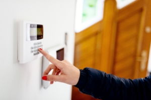 woman pressing buttons on her white burglar alarm